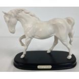 A Royal Doulton "Spirit of Freedom" ceramic horse figurine mounted on a wooden plinth. In white matt