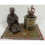After Bergman - a cold painted Arabian style inkwell. An Arabian gentleman knelt reading on a