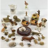 A collection of ceramic and brass dog figures. Together with Wade Whimsies, ceramic bells and