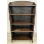A vintage dark oak bookcase with adjustable shelves and carved detail to shaped top. Approx. 115 x