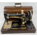 A vintage wooden cased Singer hand sewing machine with gilt detail. Complete with "Sew-Tric" motor