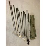 A vintage green canvas Bryant pencil style golf club bag with a collection of vintage irons and