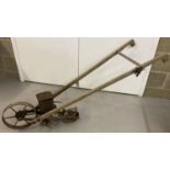 An American planet Jnr No. 4 wooden handled seed drill with cast metal wheels.