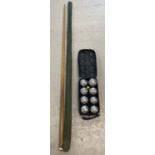 A wooden snooker cue with protective sleeve. Together with a set of metal Boules by Nauticalia,