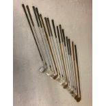 A collection of vintage hickory and metal handled golf irons in varying sizes and conditions. To