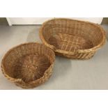 A large oval wicker dog basket to together with a round wicker pet basket. Oval approx. 89 x 75cm,