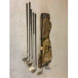 A vintage canvas and leather pencil golf bag by Bryant together with 8 vintage golf clubs in varying