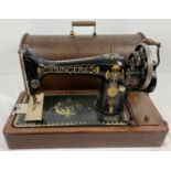 A vintage wooden cased larger sized Singer hand sewing machine with gilt floral detail. Complete