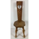 A vintage medium oak highly carved Welsh spinning chair with four legs. Heart detail to back with