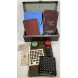 A collection of typewriter accessories in a vintage storage tin by Pilot with carry handles.