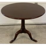 A Georgian mahogany tip top table on tripod footed pedestal base. With original brass catch to back.