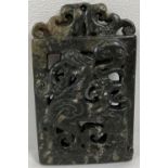 An ornately carved dark jade rectangular panel shaped pendant with mythical creature design.