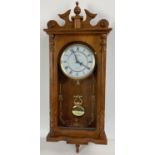 A modern wooden cased wall hanging Acctim quartz Westminster chime clock. With glass front panel,