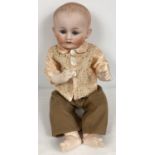An antique 17.5" Nippon bisque headed boy doll with jointed composite body. With ceramic closing
