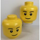 2 yellow plastic Lego storage boxes in the shape of heads. Each approx. 28cm tall.