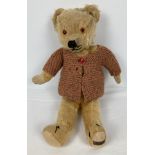 A vintage 1940's/50's Merrythought jointed teddy bear with blonde fur (worn in places). With