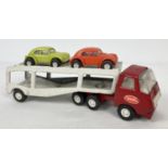 A vintage Tonka Toys car transporter with red cab, white trailer and original tyres. Carrying 2