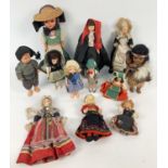 A collection of 12 vintage dolls of the world in traditional dress. Many with painted cloth faces.