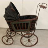 A large antique style wood and metal framed dolls pram with folding hood. Approx. 73cm x 72cm.