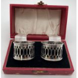 A boxed pair of Art Deco silver napkin rings with pierced design sides. Both hallmarked for