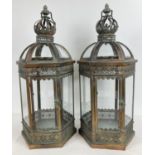 A large pair of bronzed effect hexagonal lanterns with clear glass panels. One panel hinged and with