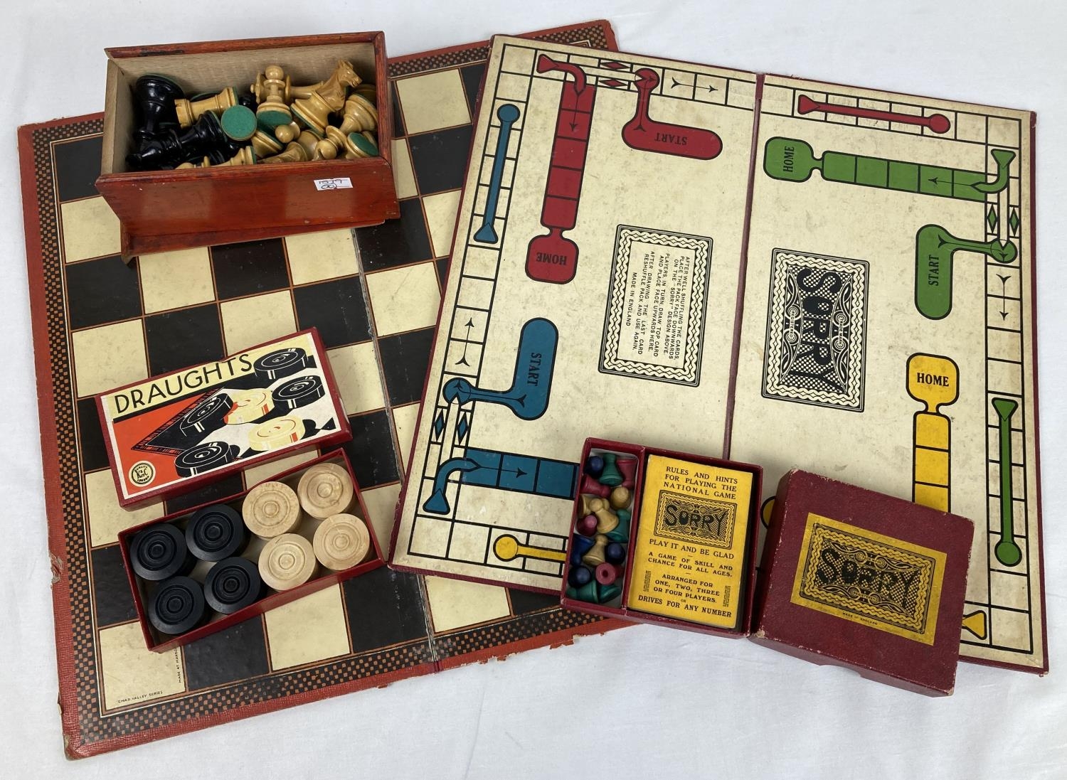 A vintage box of carved wooden chess pieces, with a Chad Valley chess board and boxed wooden