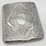 An Edwardian silver ornately engraved, curve backed cigarette case. Hallmarked B'ham 1902, with