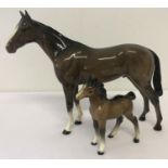 2 Beswick horse figurines. A Bois Roussell Racehorse together with a foal (a/f). Both in brown