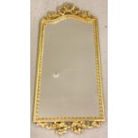 A modern gilt framed hall mirror with floral and bow detail top and bottom. Approx. 87.5cm x 39cm.