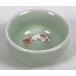 A small pale green glazed ceramic bowl with fish detail, in relief, to base of interior. Approx. 3.