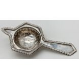 An Art Deco silver tea strainer with hexagonal shaped strainer frame. Fully hallmarked to