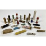A collection of vintage lipsticks and lipstick holders in varying sizes and designs, some with