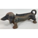 A vintage cast iron doorstop/boot scraper in the shape of a Dachshund dog. Approx. 33 x 10cm.