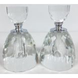 A pair of large circular shaped faceted clear glass perfume bottles. With screw lids and clear glass