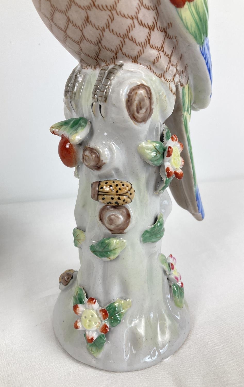 A pair of ceramic candlesticks modelled as parrots sitting atop a stump. With flower and insect - Image 4 of 4