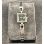 A boxed Gucci G 102 ladies wristwatch. Silver tone bracelet strap with G detail to case, black