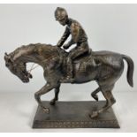 A large, heavy bronzed cast metal figurine of a horse and jockey. Approx. 39cm T x 42cm L.