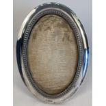 A vintage oval silver photo frame with bead style decoration to inner edge. Hallmarked Birmingham