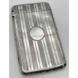 An Art Deco silver card case with engine turned design front and back. Features a blank circular