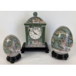 3 matching Chinese ceramic items on wooden stands. A quartz mantel clock and 2 ornamental eggs.