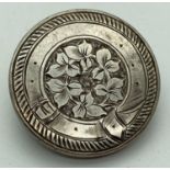 A vintage silver pin back brooch with floral detail framed with engraved belt decoration. Approx.