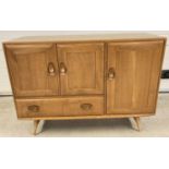 A vintage Ercol Windsor sideboard in blonde wood finish. Double door cupboard with adjustable