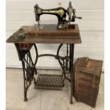 A vintage Singer treadle sewing machine with cast iron base, wooden table with draw and
