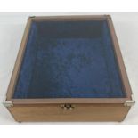 A vintage wooden jewellery display cabinet with glazed hinged lid, metal clasp and blue velvet lined