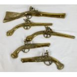 A collection of 5 vintage brass wall hanging gun ornaments. Largest approx. 46cm long.