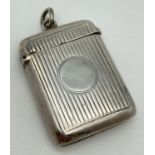 A Victorian silver vesta case with channeled detail front & back and central circular blank