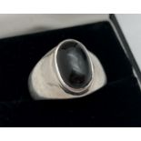 A modern silver ring set with an oval dark grey agate cabochon stone. Marked 925 to inside of