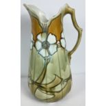 A large Art Nouveau floral design, No.12 water jug by Minton. In green and amber brown glaze.