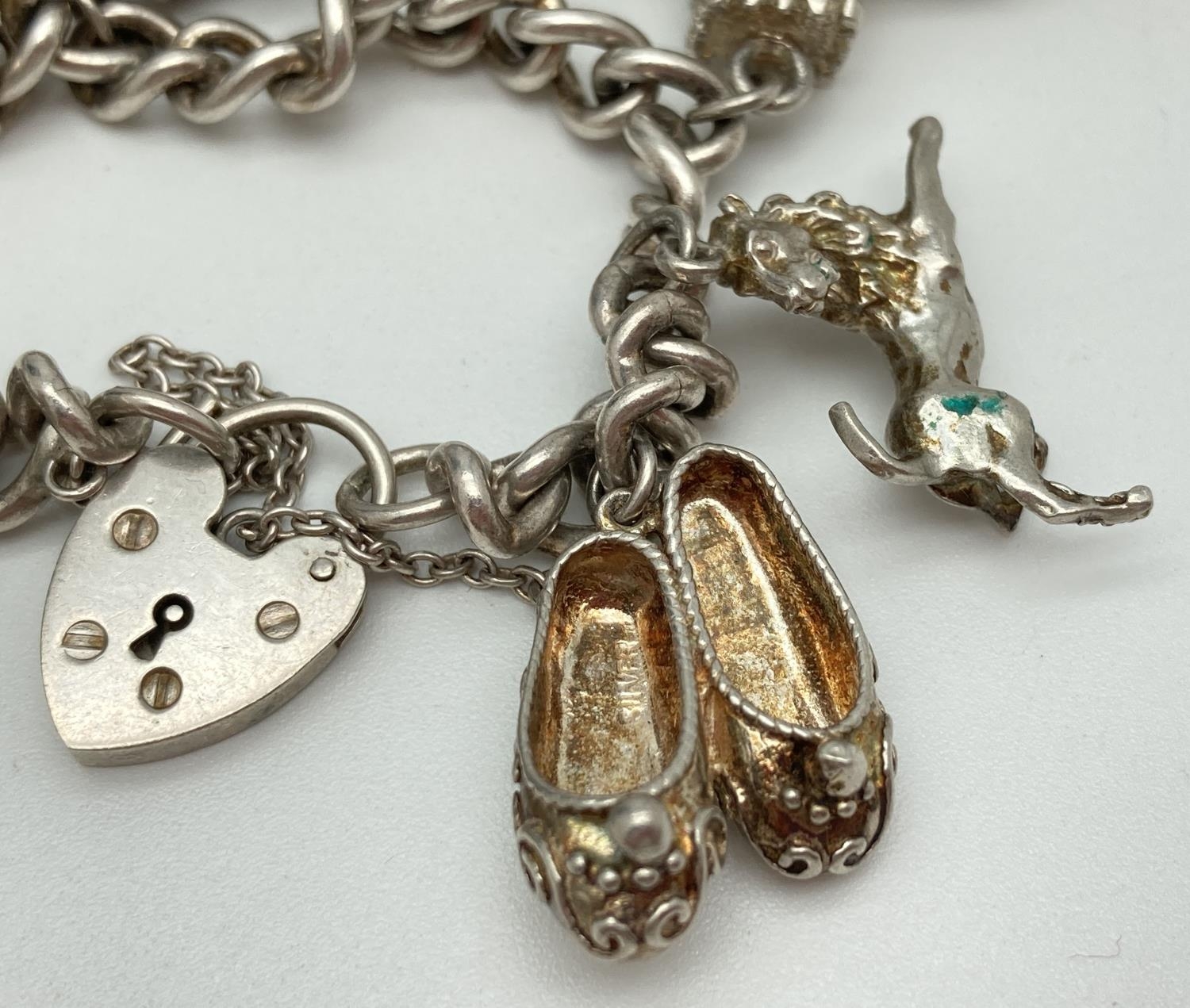 A vintage silver charm bracelet with padlock clasp, safety chain and 7 silver and white metal - Image 4 of 4