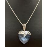 A large pale blue crystal heart shaped pendant with silver pierced work overlay and bale. On an